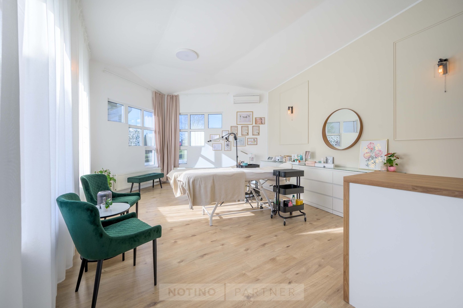 Svetlý kozmetický salón Pekná vizáž s kreslami, recepciou a ošetrovacím lôžkom